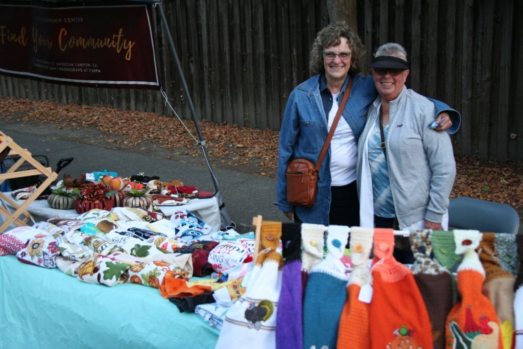Two friends sold their brightly colored hand towels in the tree shade.