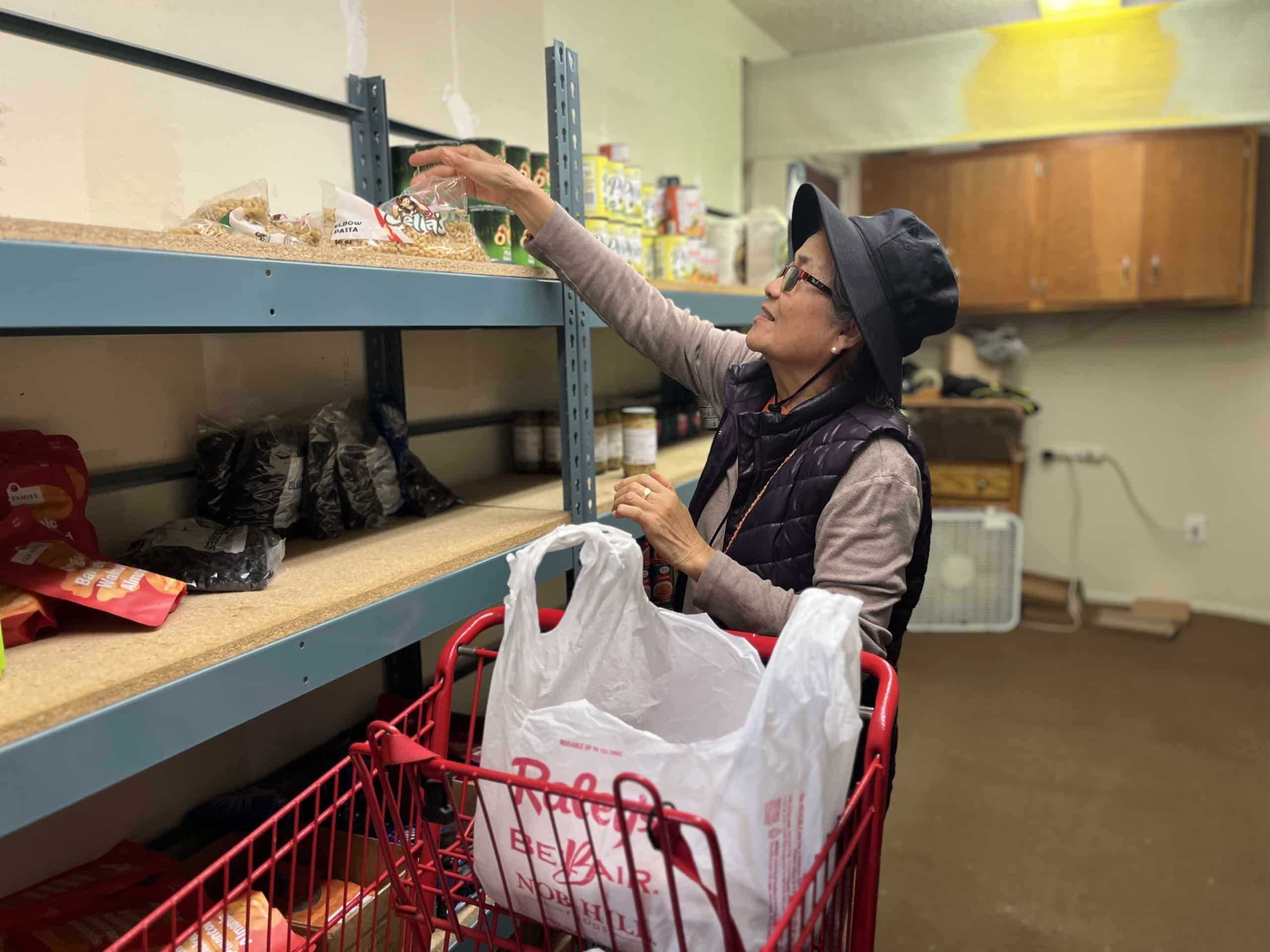 Flor Delina picks elbow pasta from the pantry. Delina lives with her husband and their daughter and cooks a majority of their meals. Griffin Jones photo