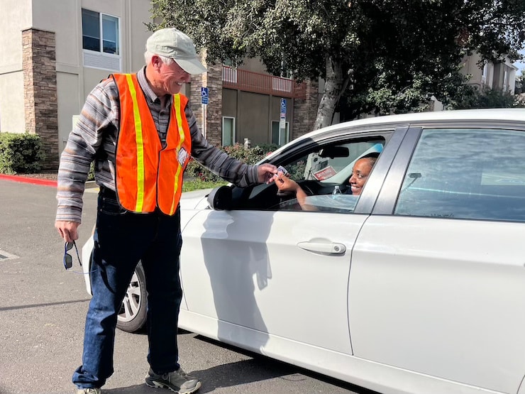 Poll worker Phil Carlson hands American Canyon resident Lydia Embry an "I voted" sticker