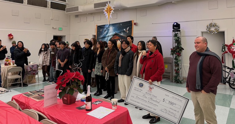 Alma Association's Karina Servente presents a check to American Canyon High School's choir after the teens performed at Saturday's posada at Mikolajcik Center in American Canyon