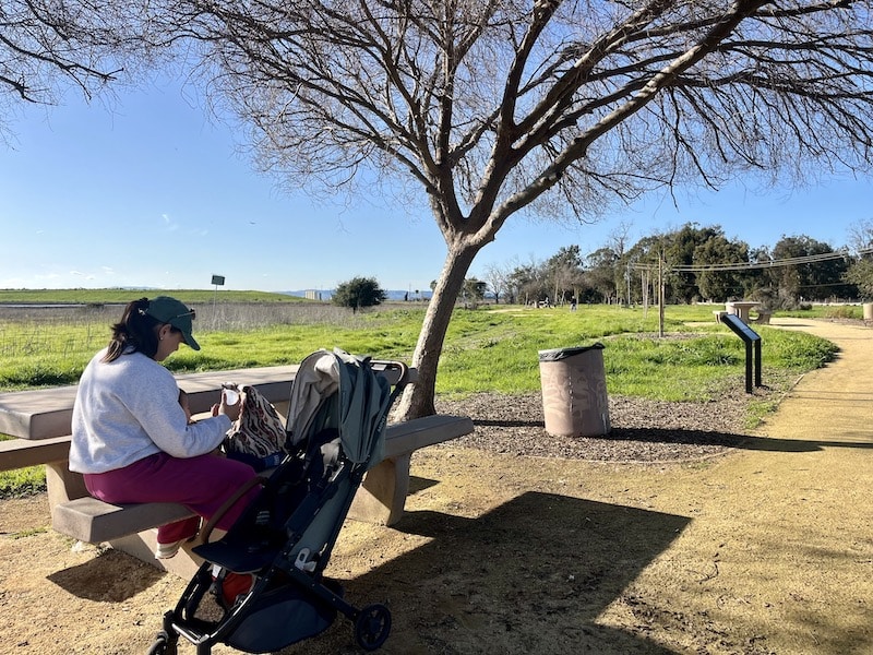 Mother and child sit on bench in park