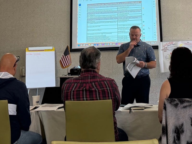 people standing or in chairs in a conference room
