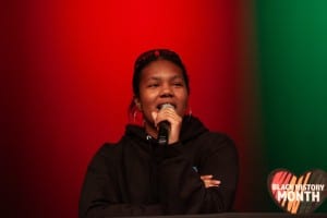 young woman holding microphone in front of red background