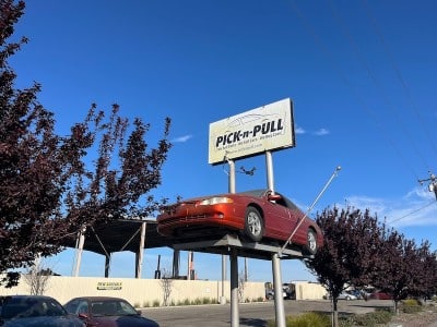 car on a post with a pick-n-pull sign on it