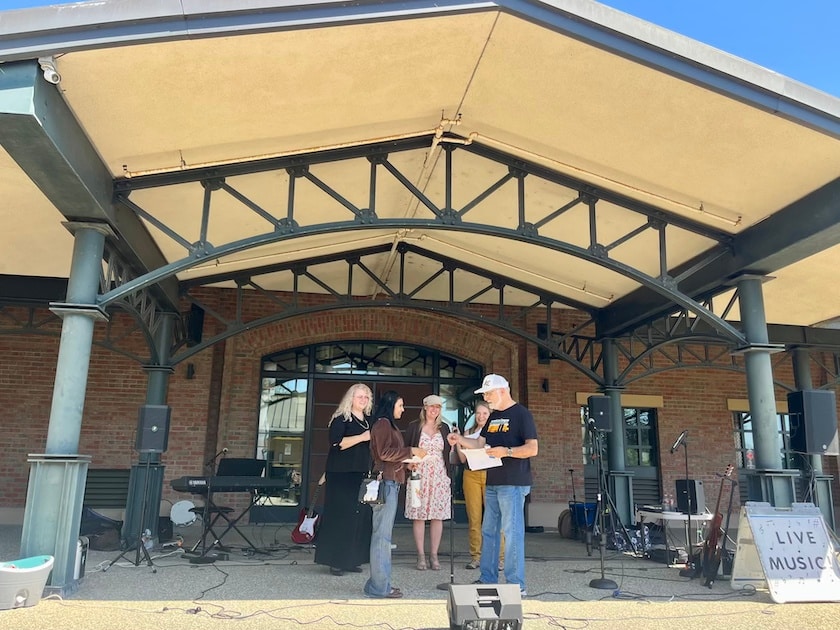 young girl getting certificate from someone as people clap