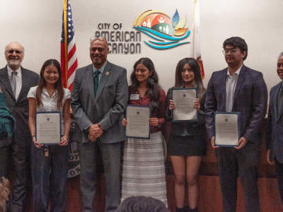 students and adults standing in a line smiling for photo