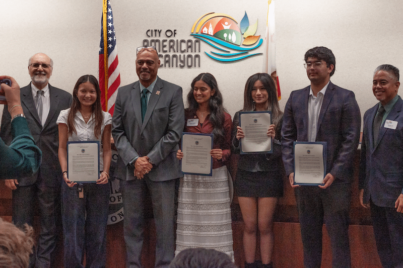 students and adults standing in a line smiling for photo