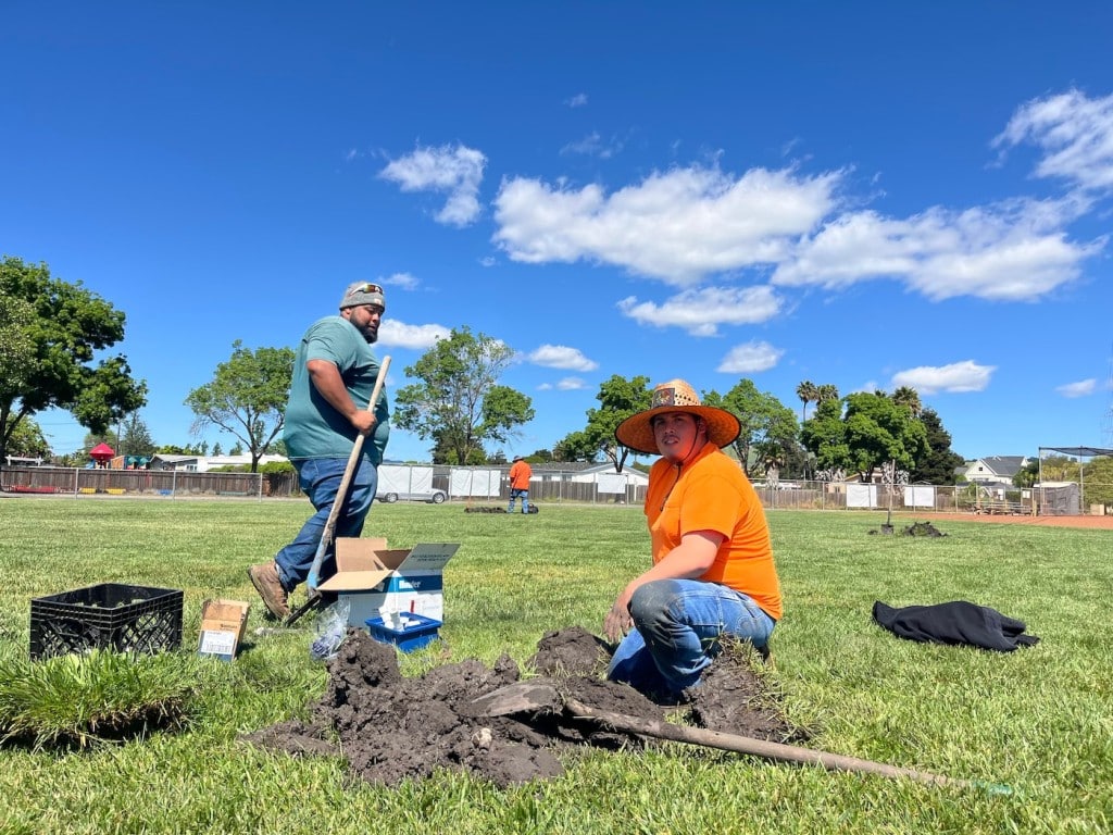 two men in park working on pipes