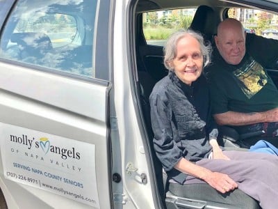two elder adults in a van