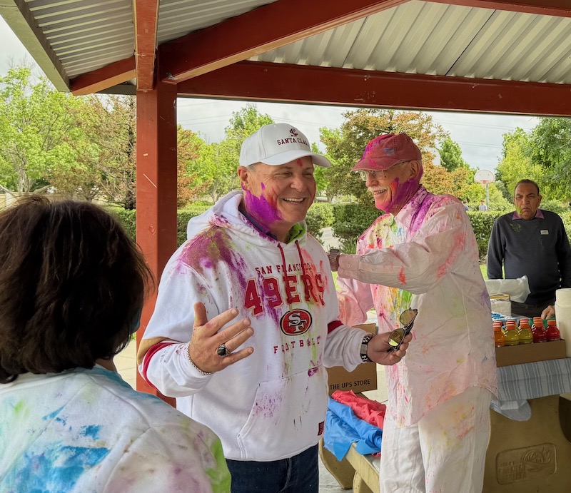 man covered in colors with two others