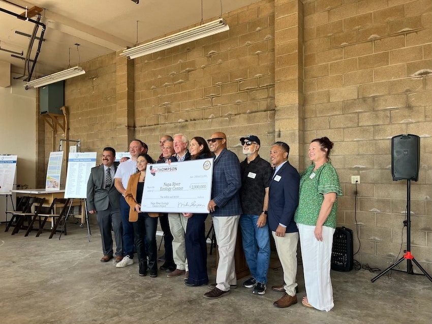 group of people standing with a novelty check