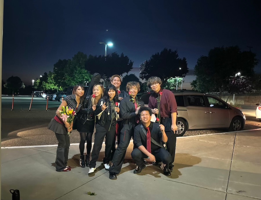group of high schoolers posing for a photo on sidewalk